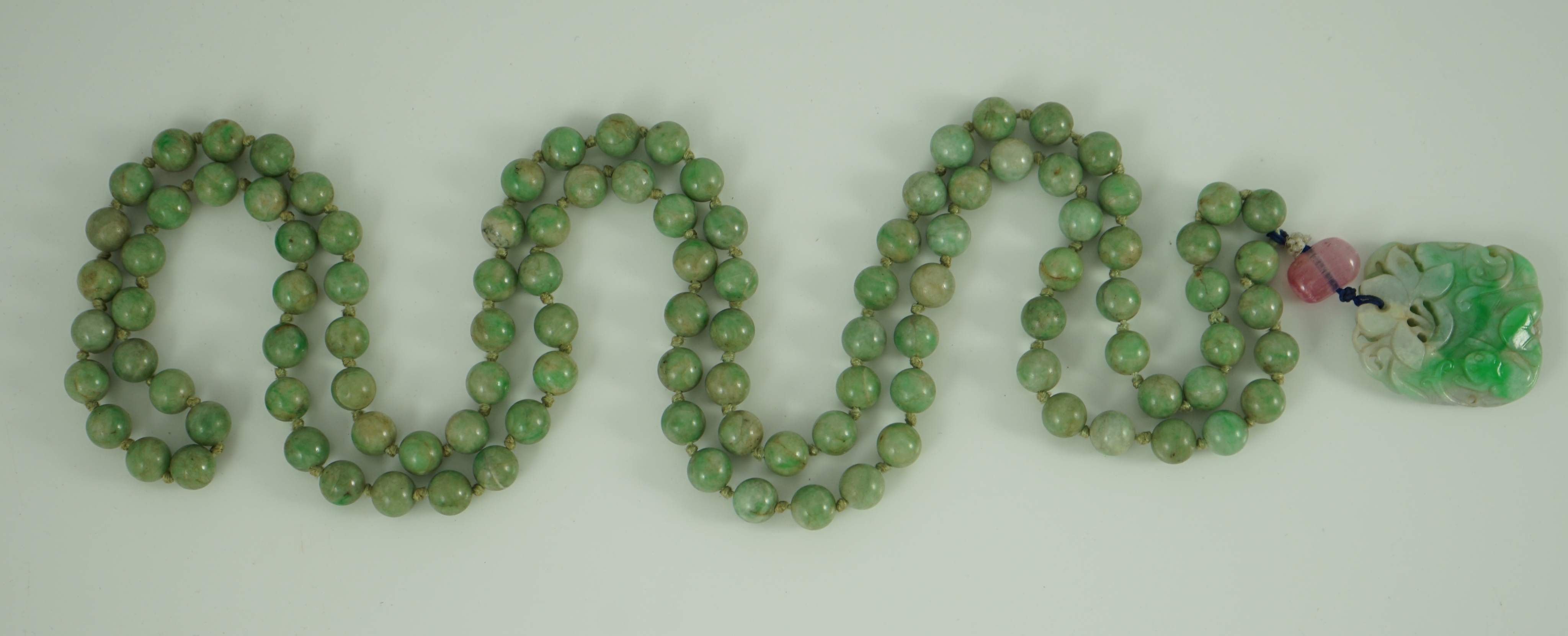 A Chinese jadeite pendant and jadeite beads, 19th century, Pendant 3.9 cm, total drop 68 cm